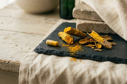Bright yellow barberry root and bark on slate beside a yellow capsule