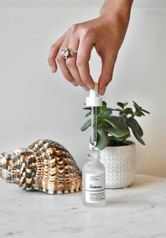 Hand holding a small wellness bottle, choosing a considered gift